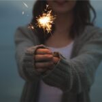 a woman is holding a sparkler in both hands