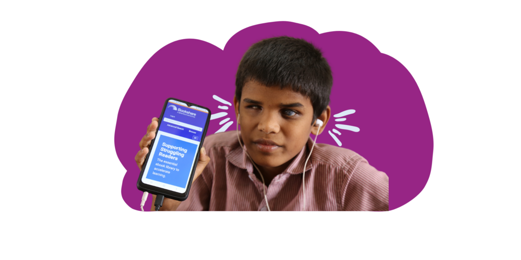 A young indian boy holding a tablet with headphones.