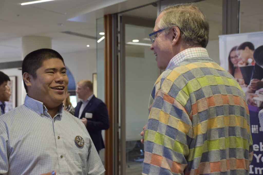Jim Fruchterman, Benetech Founder, and Kevin Leong chat, with others networking in the background.