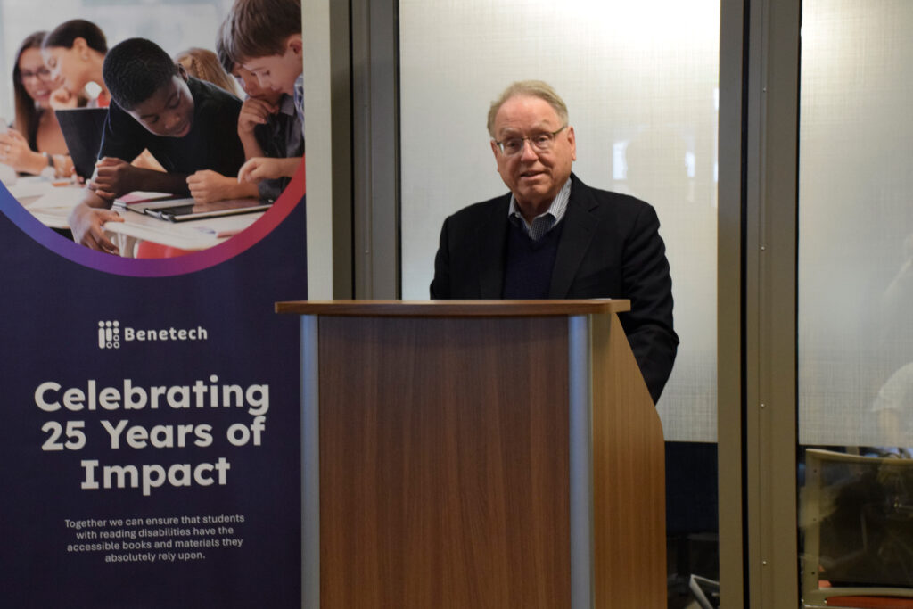 Fred Kohler speaks at a podium next to a Benetech “Celebrating 25 Years of Impact” banner.